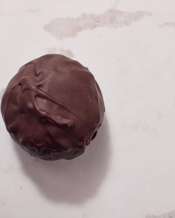 Protein Bite DONUTRI com cobertura de chocolate sobre mármore